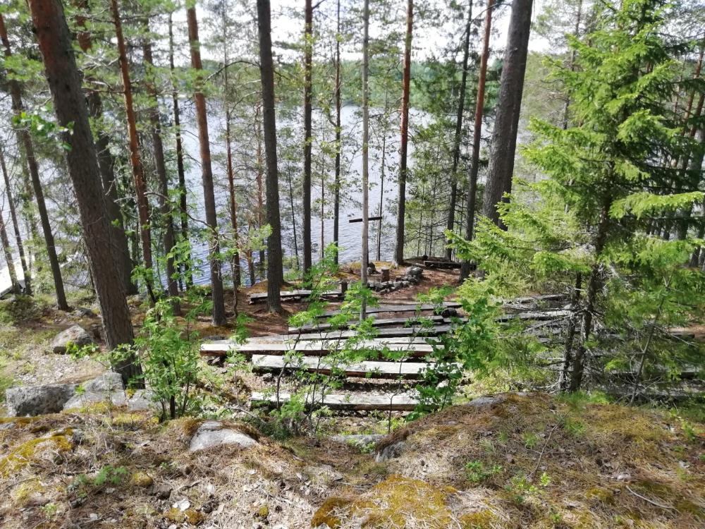 Hirsipenkit ja leirinuotiopaikka Iisaaren kalliorinteellä.