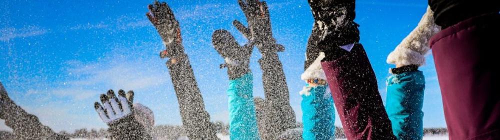 Rippikoululaisten kädet heittävät ilmaan lunta.