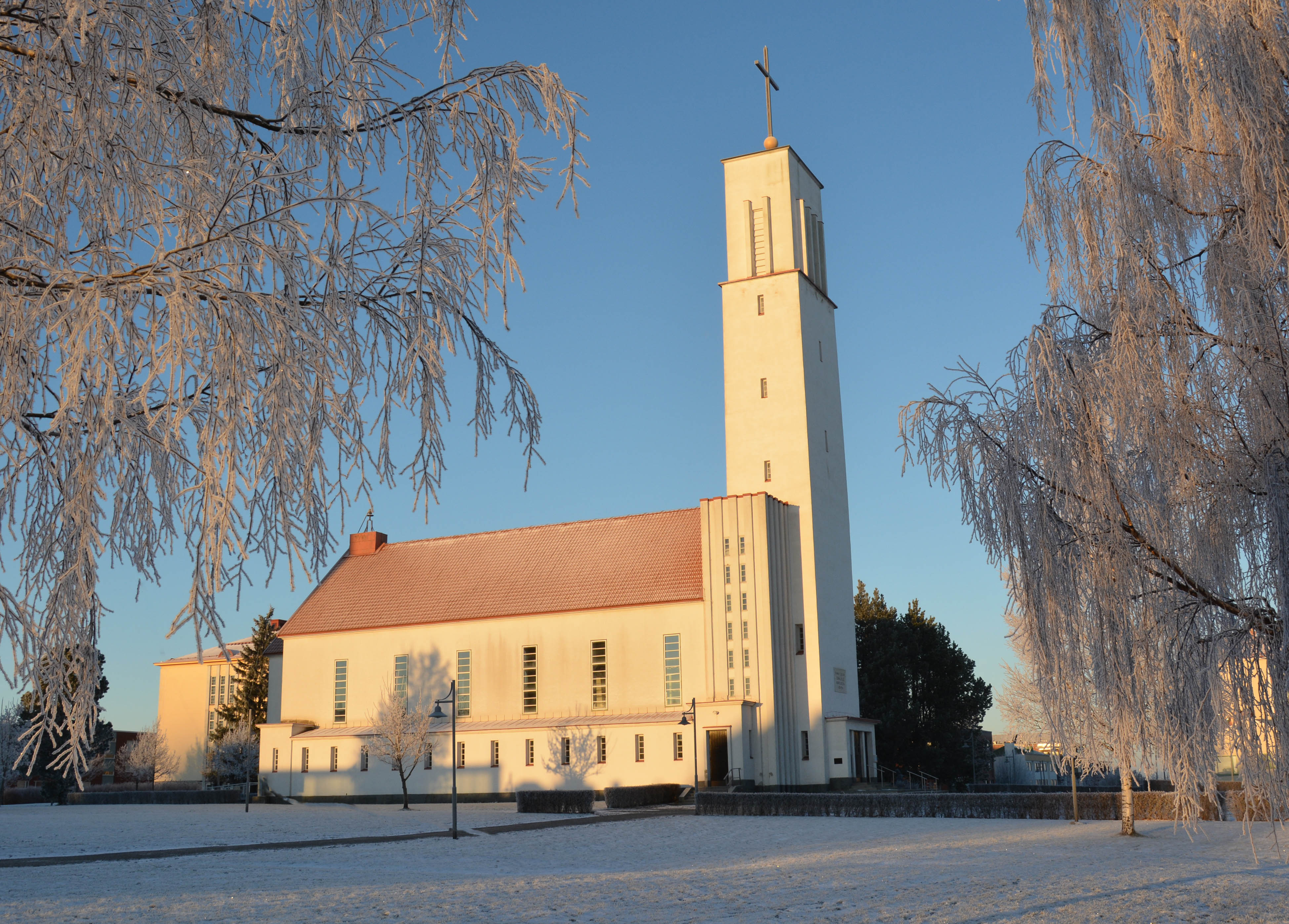Piispantarkastus - Messu Pyhän Ristin kirkossa Iisalmen Pyhän Ristin kirkko talvella auringonpaisteessa.