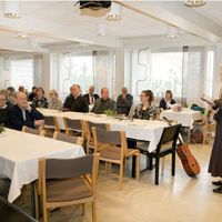 Seurakuntatalon ylä- ja alasali Ihmisiä seurakuntasalissa.