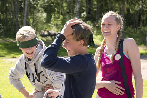 Nuoret tekee ryhmätehtävää, jossa on silmät sidottu. Nuoria naurattaa.