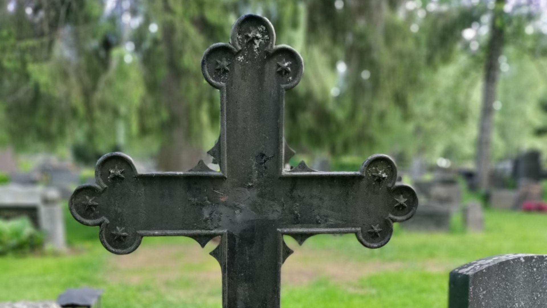 Metallinen ristin muotoinen hautamuistomerkki Vanhalla hautausmaalla.