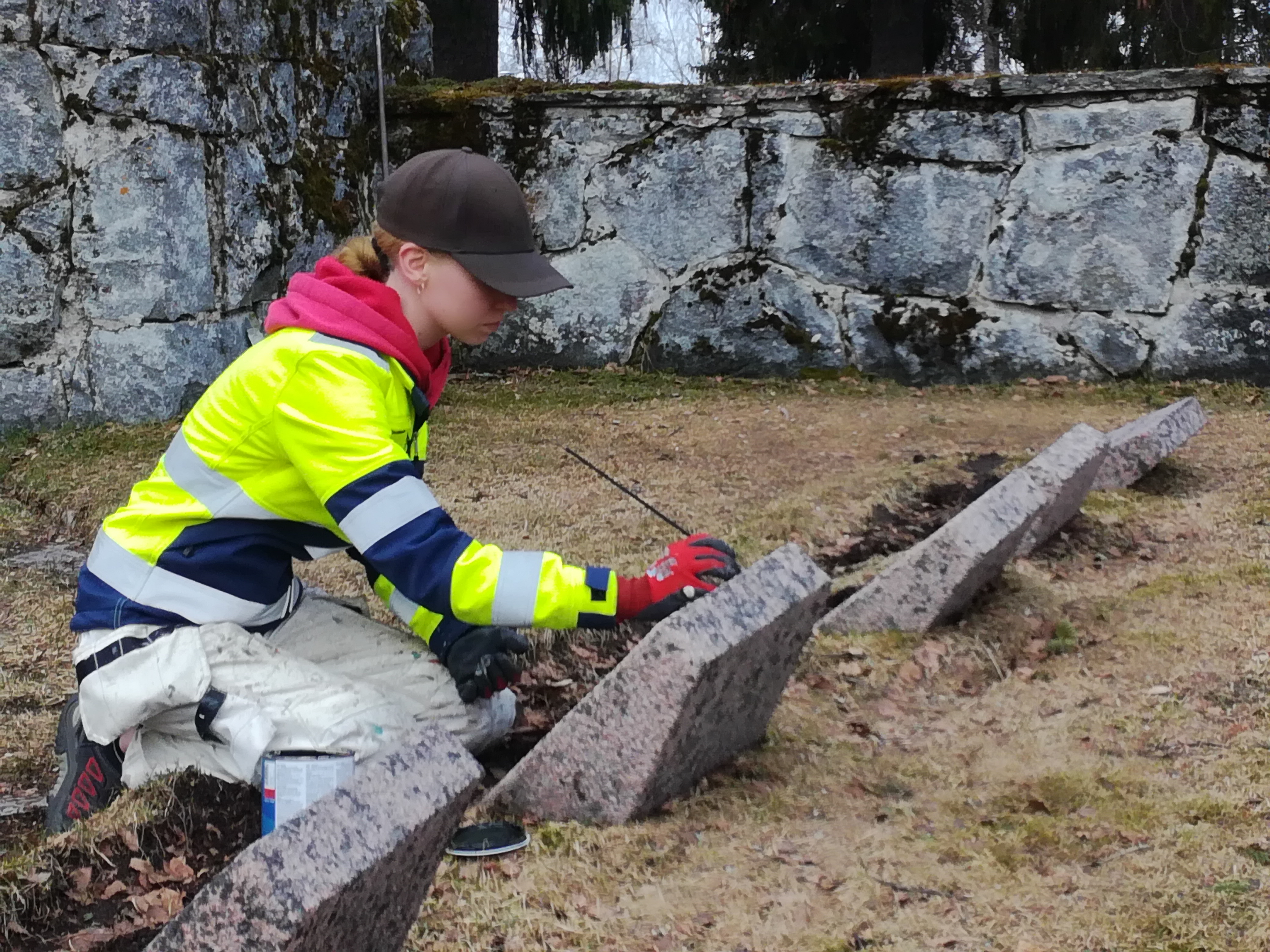 Artesaaniopiskelija Heli Korhonen korjaamassa sankarihaudan hautamuistomerkin tekstejä.