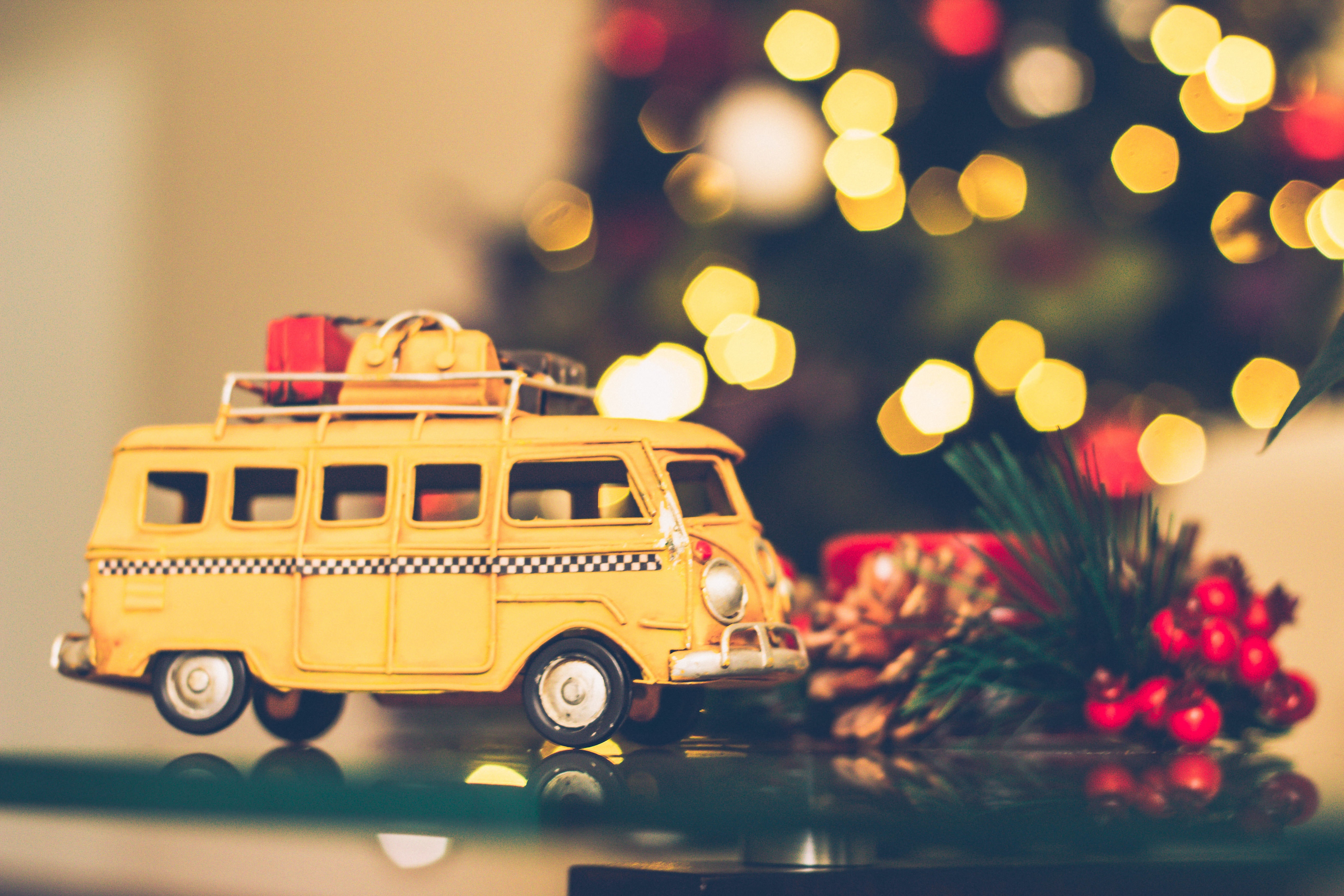 Pienoismalli pakettiauto, jonka katolla lahjapaketteja, taustalla joulukuusi.