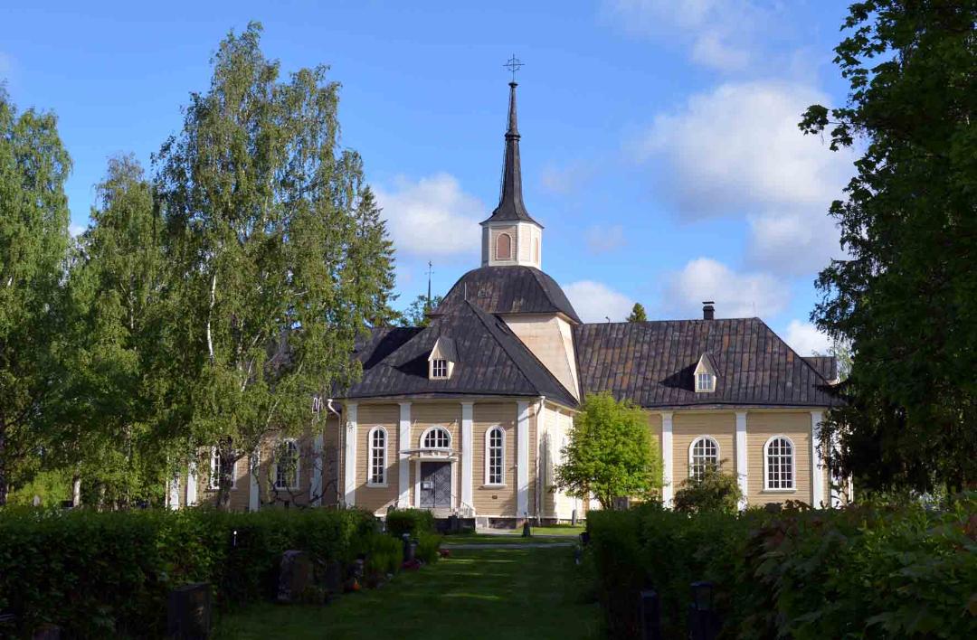 Kustaa Aadolfin kirkko, sininen taivas ja vihreät puut.